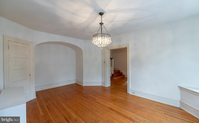 unfurnished room featuring light hardwood / wood-style floors and an inviting chandelier