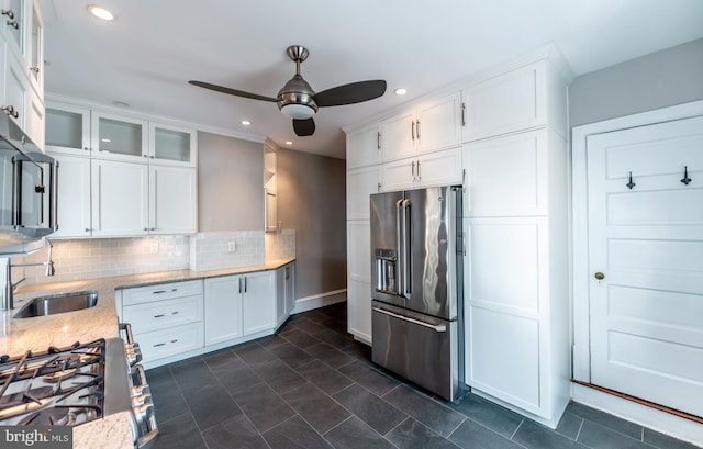 kitchen featuring white cabinets, high end fridge, light stone counters, and sink