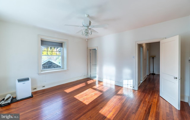 empty room with ceiling fan and dark hardwood / wood-style flooring