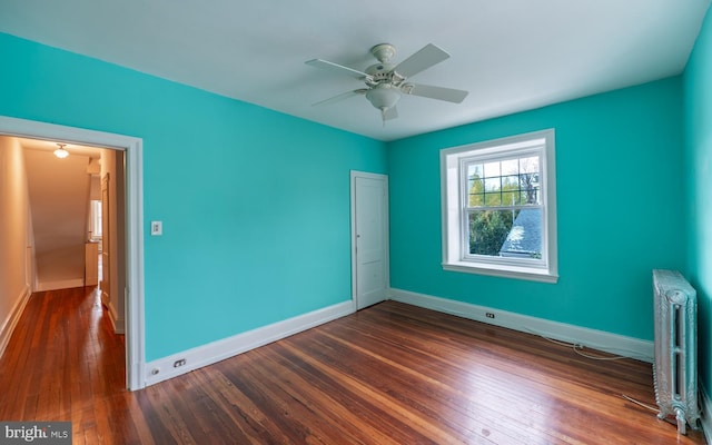 unfurnished bedroom featuring radiator, ceiling fan, and dark wood-type flooring