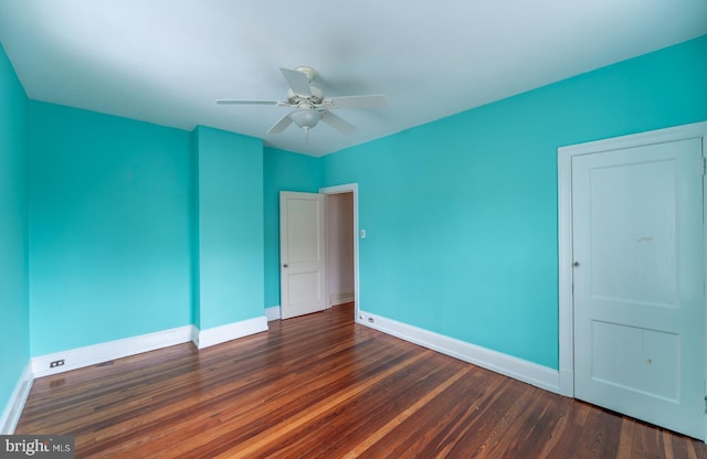 empty room with dark hardwood / wood-style floors and ceiling fan