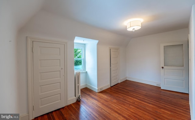 unfurnished bedroom with dark hardwood / wood-style flooring and vaulted ceiling