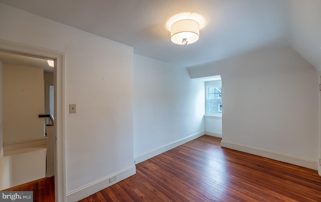 bonus room featuring dark wood-type flooring and vaulted ceiling