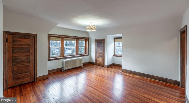 interior space with wood-type flooring and radiator heating unit