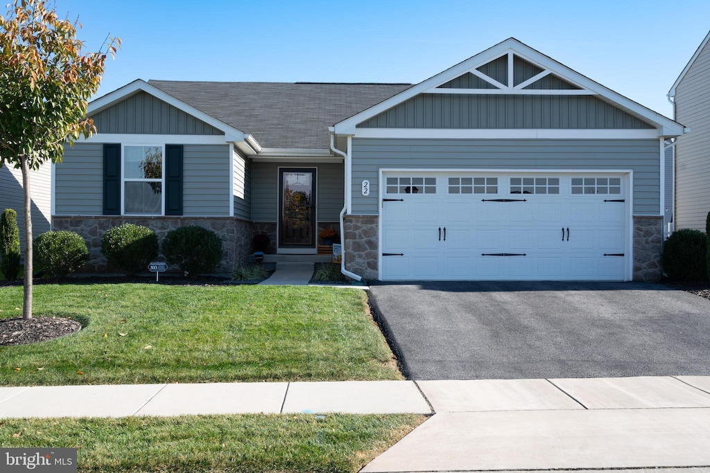 craftsman-style home featuring a garage and a front lawn