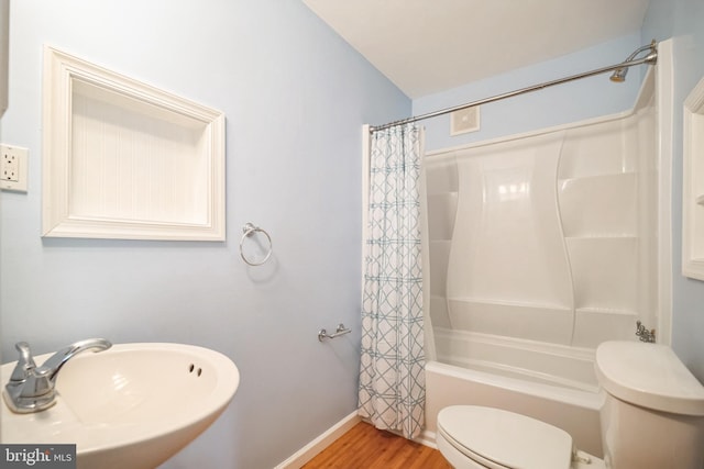 full bathroom featuring shower / bath combo with shower curtain, toilet, sink, and hardwood / wood-style flooring