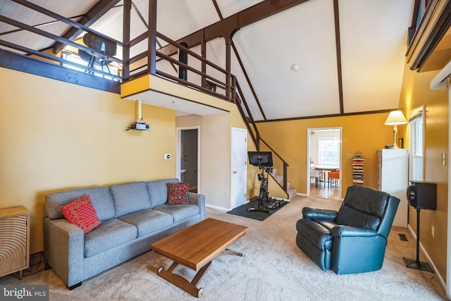 carpeted living room featuring beam ceiling and high vaulted ceiling