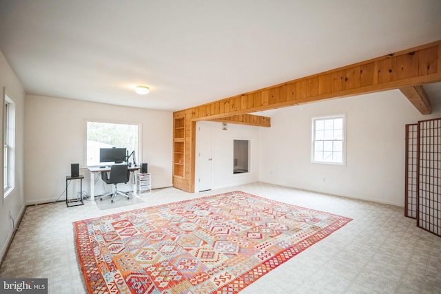 interior space featuring a healthy amount of sunlight, light colored carpet, and beam ceiling