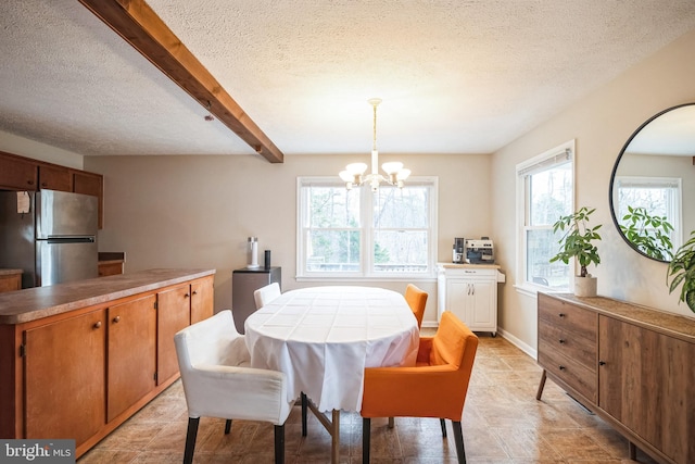 dining room featuring beam ceiling, a textured ceiling, and an inviting chandelier