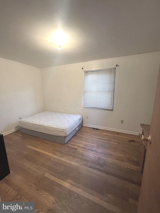 unfurnished bedroom with dark hardwood / wood-style floors