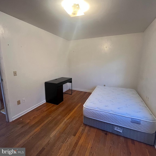 bedroom with dark hardwood / wood-style flooring