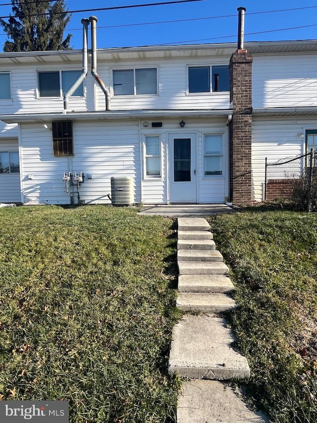 view of front of property featuring central AC unit and a front yard