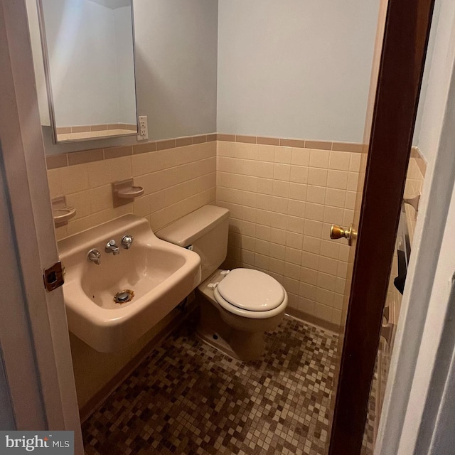 bathroom with tile patterned floors, sink, tile walls, and toilet