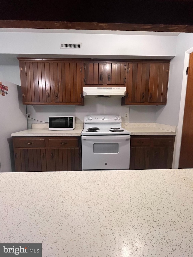 kitchen with dark brown cabinetry and white appliances