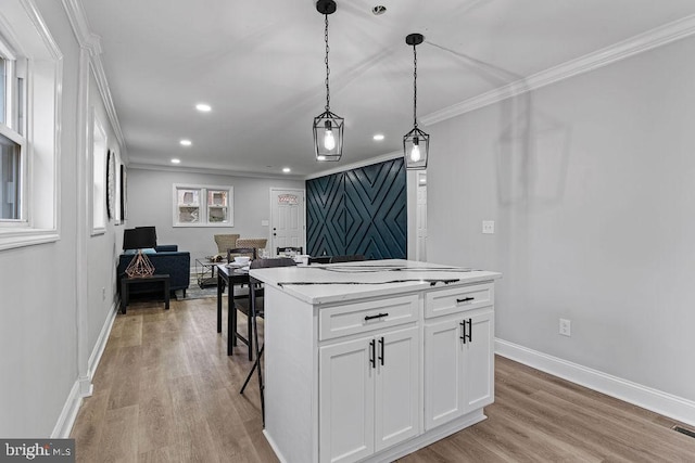 kitchen with a kitchen breakfast bar, light wood-type flooring, a kitchen island, white cabinetry, and hanging light fixtures