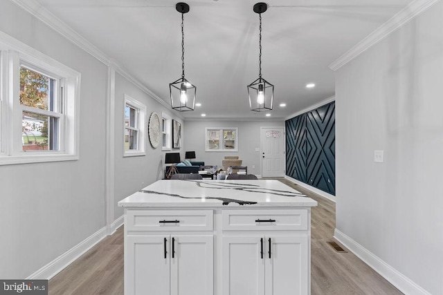 kitchen featuring pendant lighting, light hardwood / wood-style floors, a kitchen island, and white cabinetry