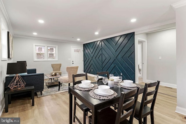 dining room featuring light wood-type flooring and crown molding