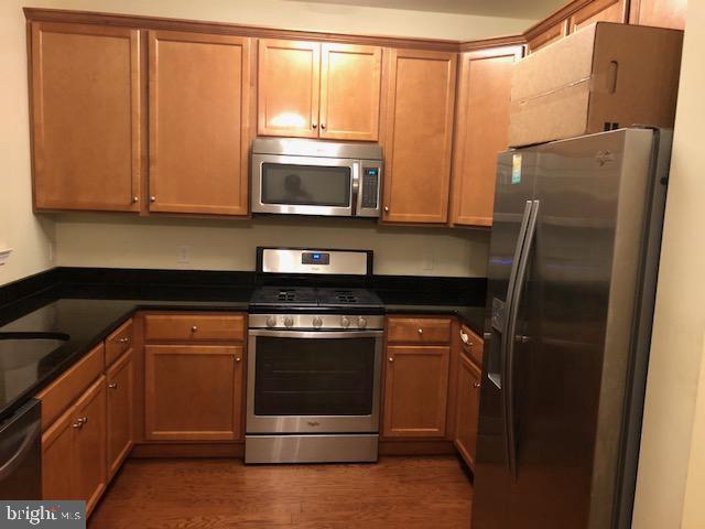 kitchen with stainless steel appliances and dark wood-type flooring