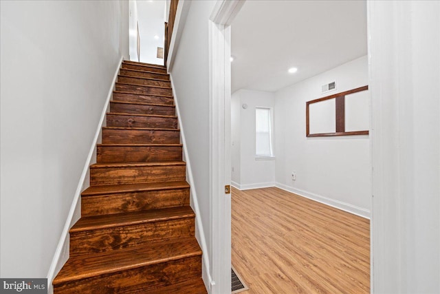 stairs featuring hardwood / wood-style flooring