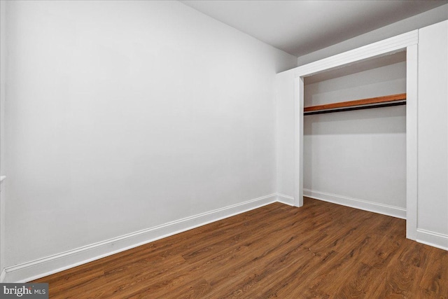 unfurnished bedroom featuring dark hardwood / wood-style floors and a closet