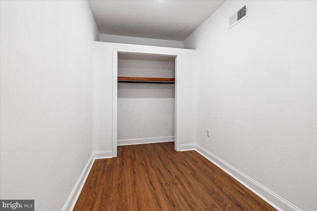 unfurnished bedroom featuring dark hardwood / wood-style flooring and a closet