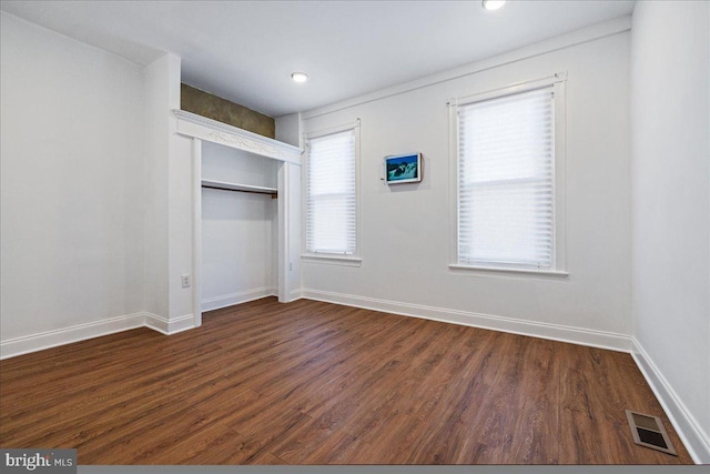 unfurnished bedroom featuring dark hardwood / wood-style floors and a closet