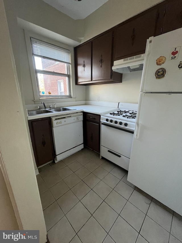 kitchen featuring dark brown cabinets, white appliances, sink, and light tile patterned floors