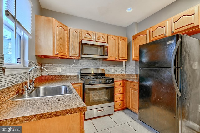 kitchen with decorative backsplash, light tile patterned flooring, sink, and stainless steel appliances