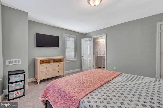 bedroom featuring light carpet and ensuite bathroom