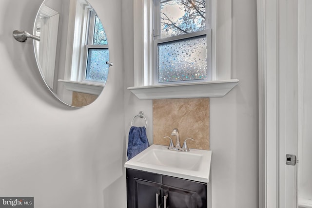 bathroom with vanity, tasteful backsplash, and a wealth of natural light