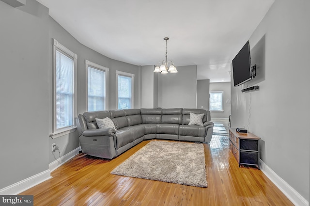 living room with wood-type flooring and an inviting chandelier