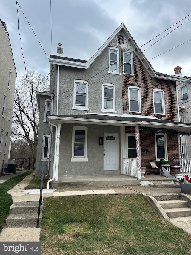 townhome / multi-family property with a front lawn, central AC unit, and a porch