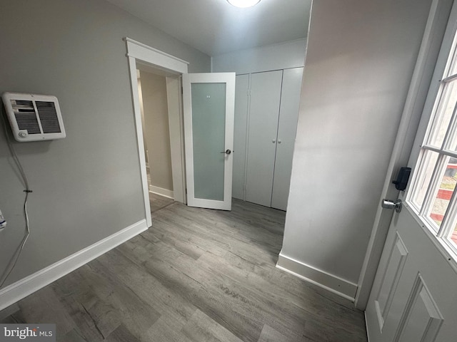 hall with an AC wall unit and light hardwood / wood-style flooring