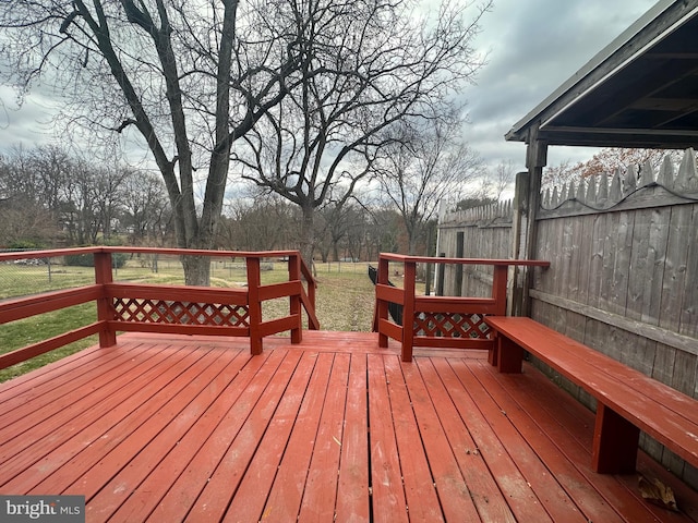 wooden deck featuring a lawn