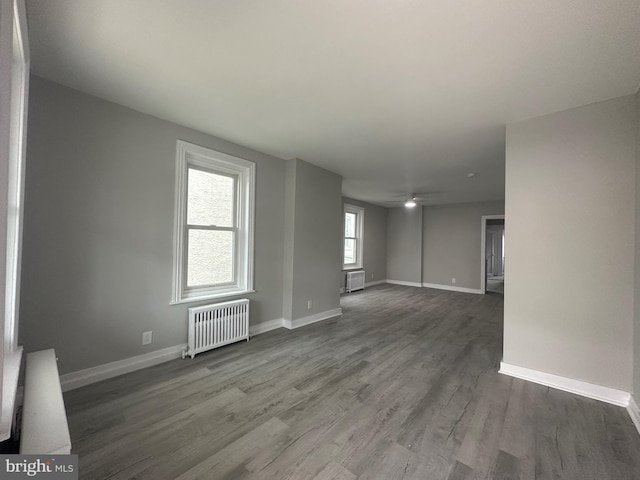 spare room with hardwood / wood-style flooring and radiator heating unit