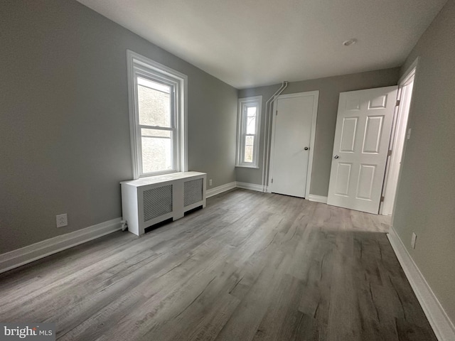 interior space featuring radiator heating unit and light wood-type flooring