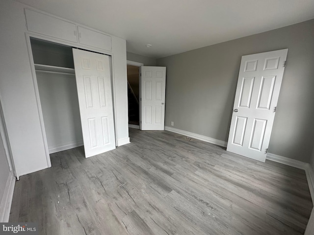 unfurnished bedroom with a closet and light hardwood / wood-style flooring