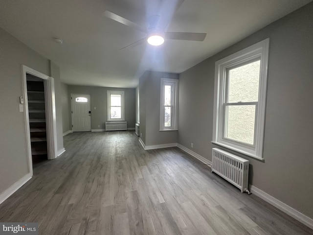 foyer with radiator, a wealth of natural light, and light hardwood / wood-style floors