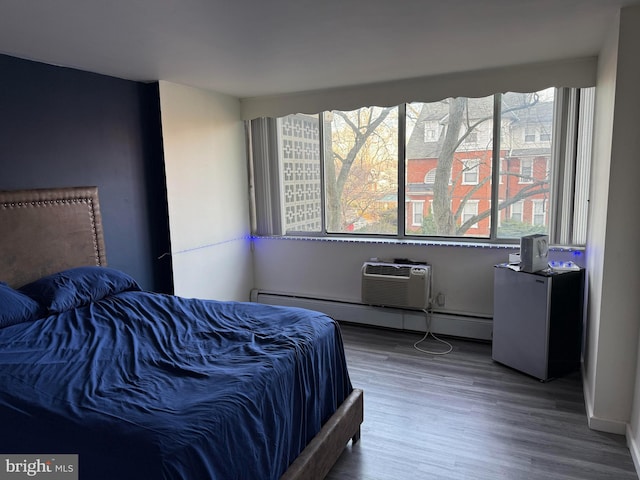 bedroom with multiple windows, hardwood / wood-style floors, and a wall mounted AC