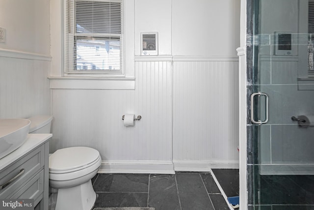 bathroom featuring an enclosed shower, vanity, and toilet