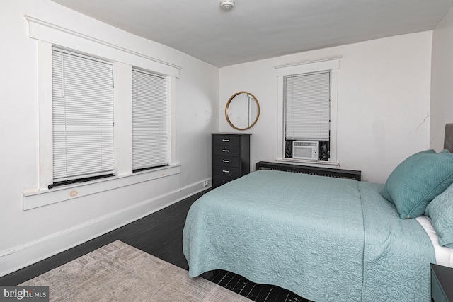 bedroom featuring dark hardwood / wood-style floors, cooling unit, and radiator heating unit