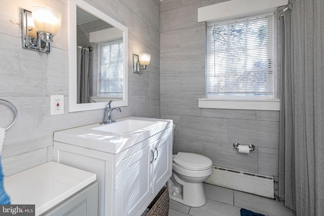 bathroom featuring tile patterned floors, vanity, a baseboard radiator, tile walls, and toilet