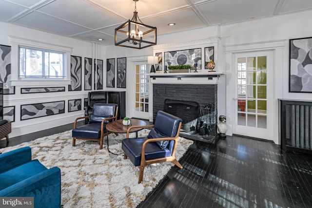 living room featuring a fireplace, dark hardwood / wood-style floors, a healthy amount of sunlight, and coffered ceiling