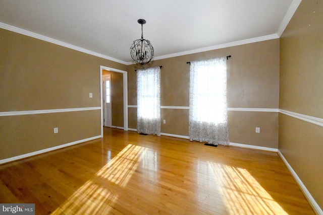 unfurnished room with hardwood / wood-style flooring, a chandelier, and ornamental molding