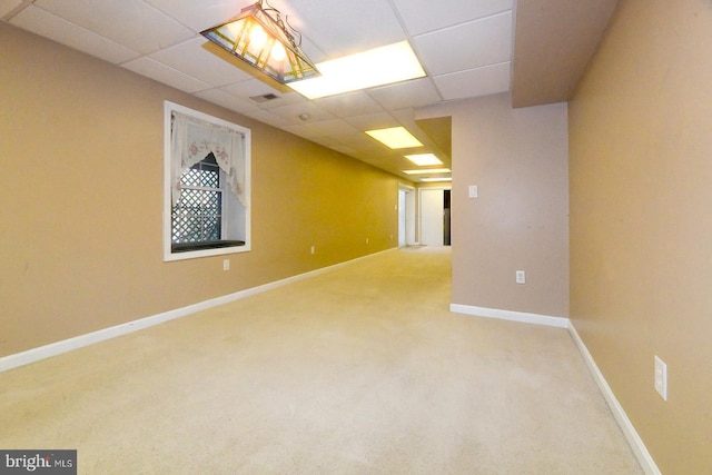 basement with a paneled ceiling and carpet flooring