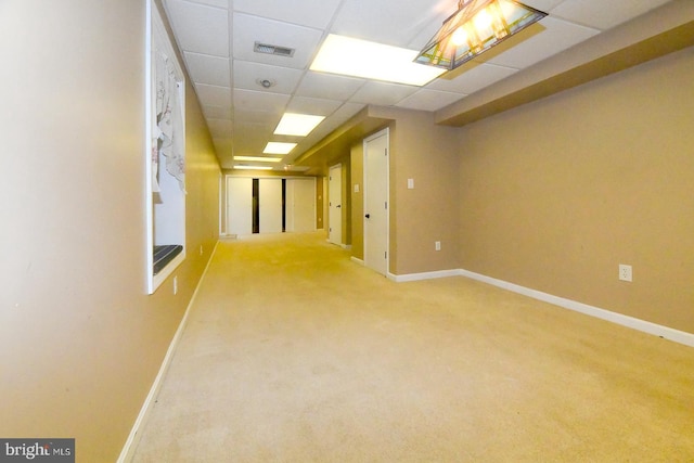 carpeted empty room with a drop ceiling