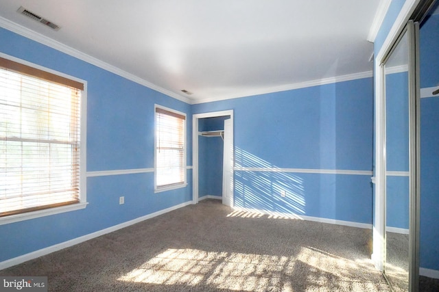 spare room with crown molding, carpet, and a wealth of natural light