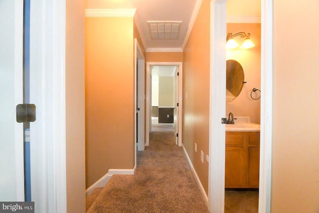 hall with sink, carpet flooring, and ornamental molding