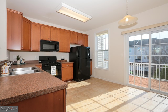 kitchen with sink, hanging light fixtures, and black appliances