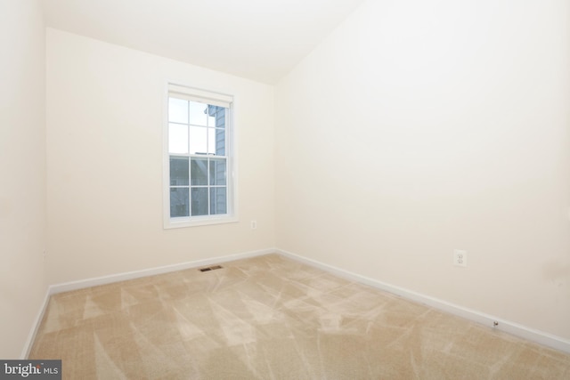 spare room with lofted ceiling and light carpet